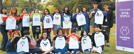 CJ그룹의 꿈키움창의학교 패션부문에서 교육을 받고 있는 청소년들이 임성호 디자이너와 함께 디자인한 티셔츠를 베트남 닌투언성 땀응언마을 럼선A초등학교 학생들에게 선물했다.    CJ그룹 제공